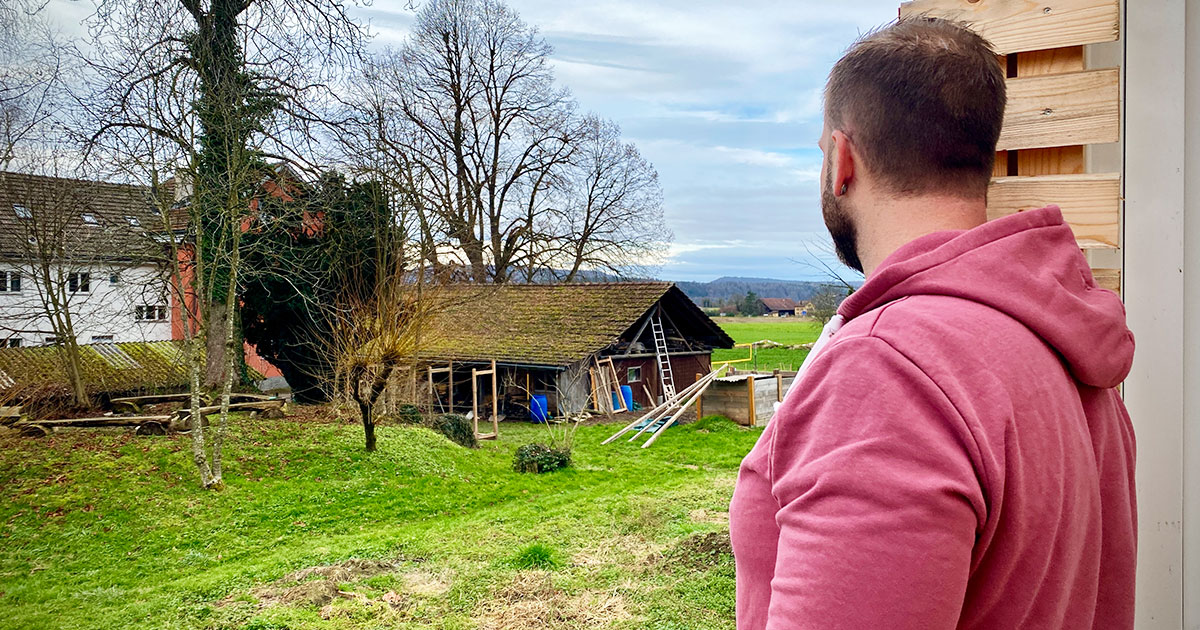 Dean* steht vor dem Bungalow und sieht auf das Areal der Therapie Bülach.